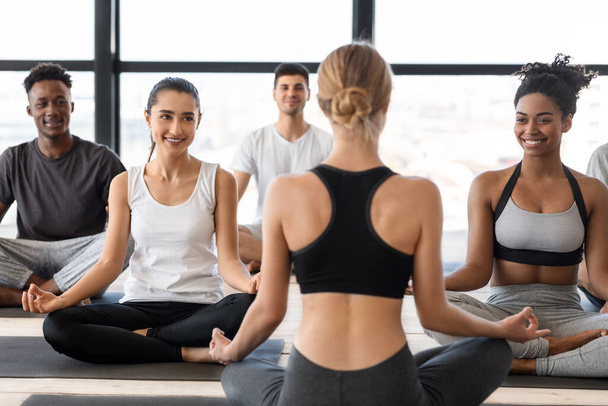 Group of multicultural man and woman practicing yoga with instructor in studio - Photo, Image