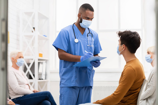 Лікар розмовляє з хворим пацієнтом про ковід-19 симптоми в лікарні
 - Фото, зображення