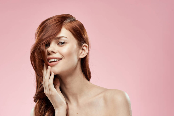 Csinos nő hosszú szép haj ápolás frizura glamor meztelen vállak rózsaszín háttér - Fotó, kép