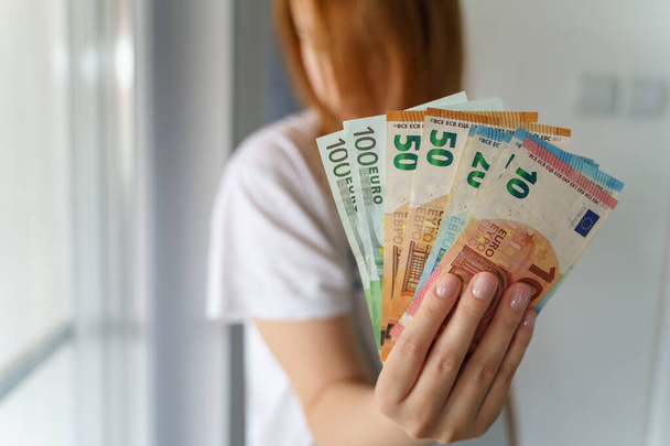 Закріпіть з рук невідомої жінки, що тримає купу грошей EURO EUR, рахуючи заробітну плату, яку отримують, або готуючись сплатити рахунки. - Фото, зображення