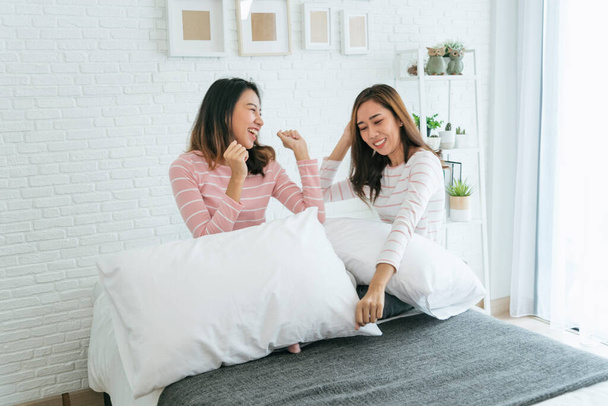 Two pretty best friends forever girlfriend talk, hug and laugh together on bed at cozy home relation fall in love. Lesbian couple homosexual happy lifestyle on bed. LGBTQ relation lifestyle concept. - Fotografie, Obrázek