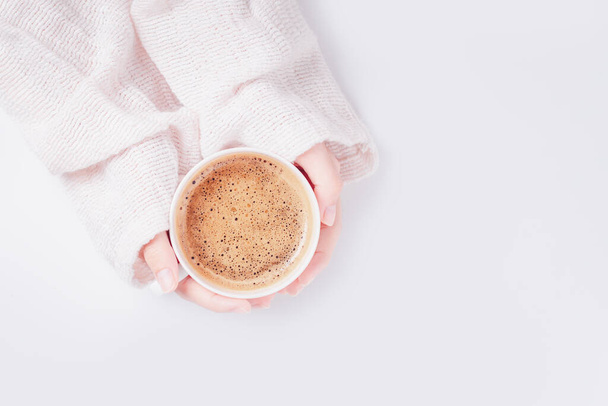Καφές latte στο χέρι θηλυκό σε λευκό φόντο. Κλείσε. Άνω όψη. - Φωτογραφία, εικόνα
