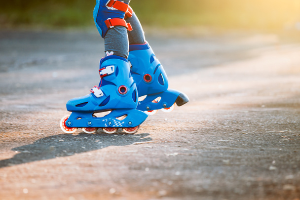 Kid riding on roller skates in the park - Photo, Image