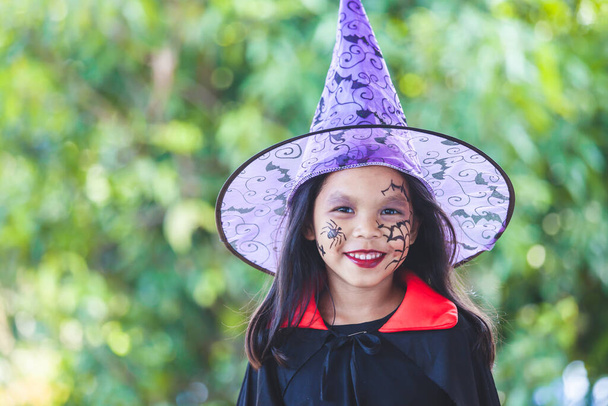 Cadılar bayramı kostümü ve makyaj giymiş şirin Asyalı kız Cadılar Bayramı kutlamasında eğleniyor. - Fotoğraf, Görsel