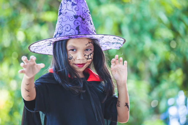 lindo asiático niño chica usando halloween trajes y maquillaje tener divertido en halloween celebración - Foto, Imagen