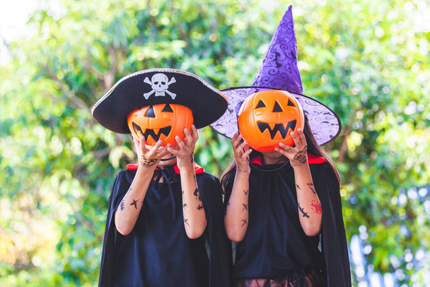 Two asian child girls in halloween costumes and makeup having fun on Halloween celebration - Foto, Imagen