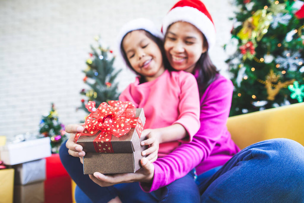 Roztomilé asijské dítě dívka s její matkou drží krásný dárek box a překvapení s dárkem v vánoční oslavy - Fotografie, Obrázek