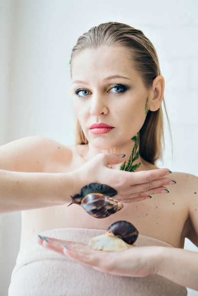 model holds snail on hand. ads for cosmetics, anti-gravity creams, lip treatments, face treatments, botax, rejuvenation, healthy nutrition, wrinkles and anti-wrinkles. Concept of French cuisine - 写真・画像