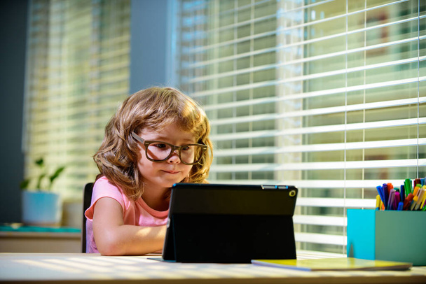 Smart little boy watch online video lesson at home, small child in glasses have web video class on computer, study at home, homeschooling concept. - Foto, afbeelding