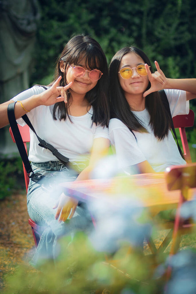 dos alegre asiático adolescente relajarse en parque - Foto, imagen