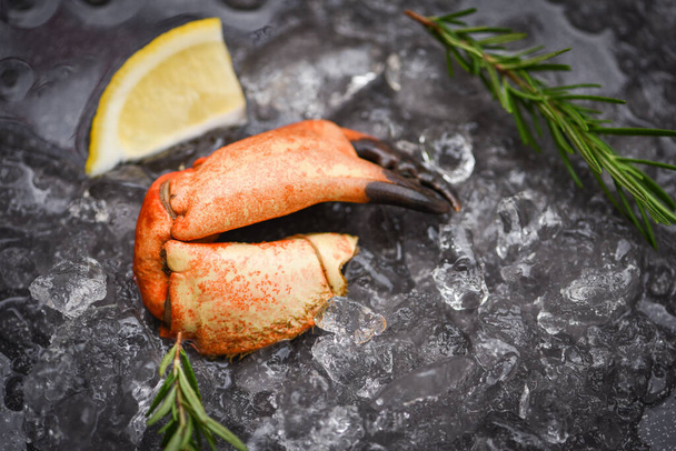 Seafood frozen boiled crab claws / Fresh crab with ingredients lemon rosemary on ice at market  - Photo, Image
