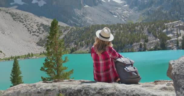 Mulher olhando para a vista da natureza do lago no dia ensolarado. Wanderlust, viagens de férias, 4K - Filmagem, Vídeo