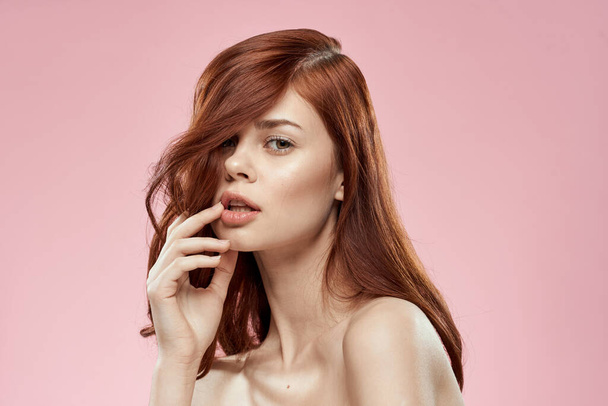 Csinos nő hosszú szép haj ápolás frizura glamor meztelen vállak rózsaszín háttér - Fotó, kép