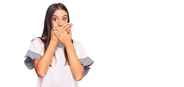 Молода іспаномовна жінка в повсякденному одязі шокувала, прикриваючи рот руками за помилку. секретна концепція
.  - Фото, зображення