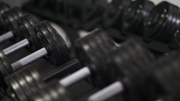 A man takes heavy dumbbells in the gym with his hands. close up. - Footage, Video