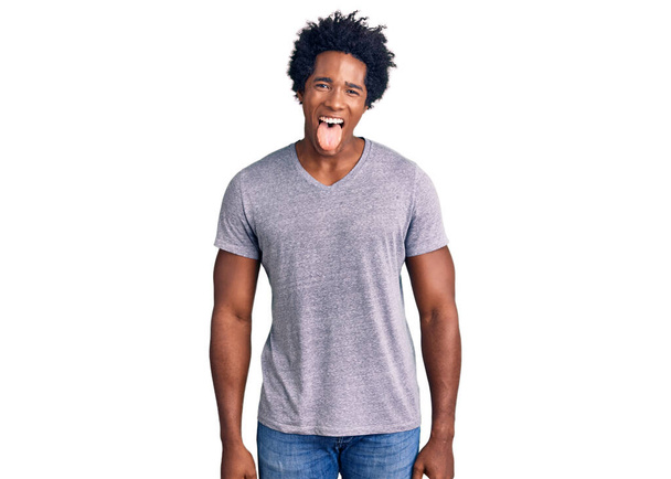 Handsome african american man with afro hair wearing casual clothes sticking tongue out happy with funny expression. emotion concept.  - Φωτογραφία, εικόνα