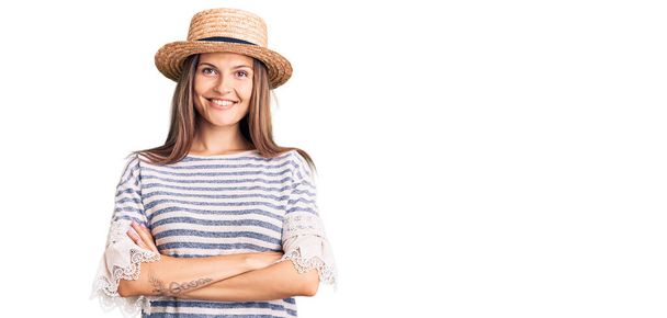 Belle femme caucasienne portant un chapeau d'été heureux visage souriant avec les bras croisés regardant la caméra. personne positive.  - Photo, image