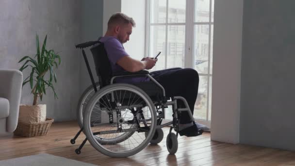 Άνδρας που χρησιμοποιεί κινητό τηλέφωνο σε αναπηρική καρέκλα - Πλάνα, βίντεο
