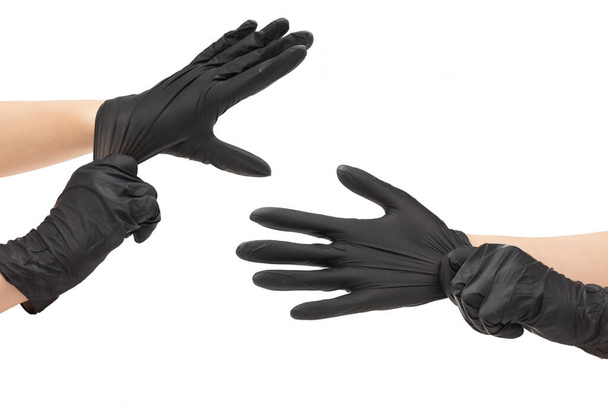Woman puts on black rubber gloves. Isolated on white. - Photo, Image