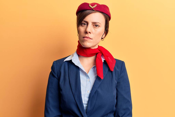 Mladá krásná žena v uniformě letušky se uvolnila s vážným výrazem ve tváři. jednoduchý a přirozený pohled do kamery.  - Fotografie, Obrázek