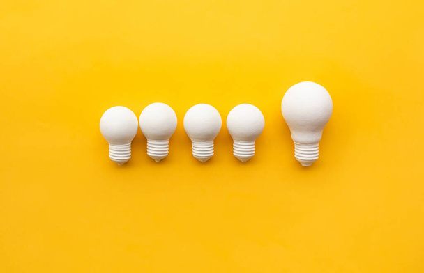 Geschäftliche Kreativität und Führungskonzepte mit Glühbirne auf gelbem Hintergrund. Motivation für Erfolg. Große Ideen denken - Foto, Bild