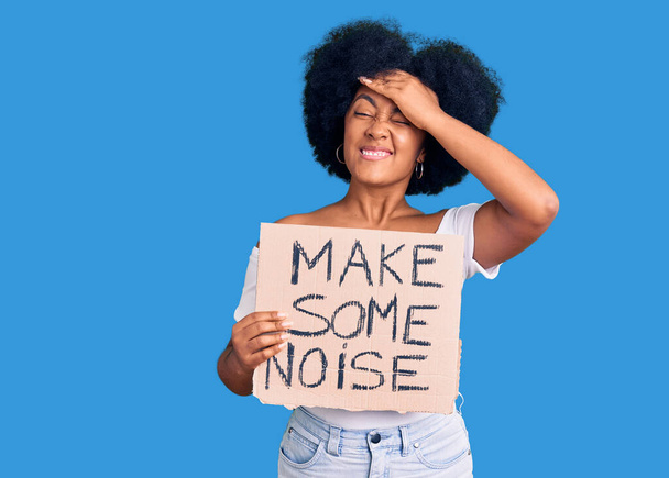 Young african american girl holding make some noise banner stressed and frustrated with hand on head, surprised and angry face  - Photo, Image
