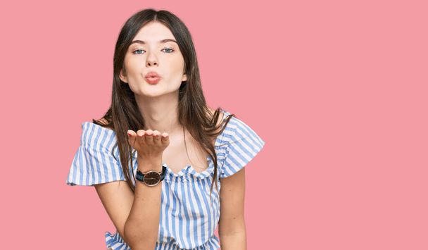 Young beautiful caucasian girl wearing casual clothes looking at the camera blowing a kiss with hand on air being lovely and sexy. love expression.  - Photo, Image