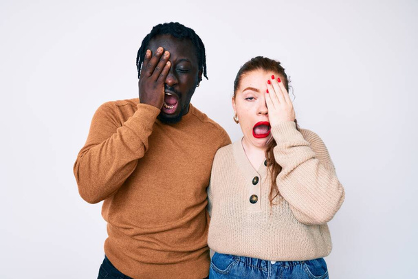 Interracial couple wearing casual clothes yawning tired covering half face, eye and mouth with hand. face hurts in pain.  - Photo, Image