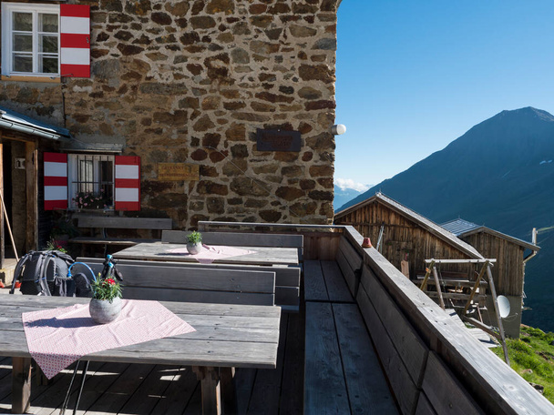 empty terrace of Nurnberger Hutte mountain hut at valley with sharp mountain peaks at Stubai hiking trail, Stubai Hohenweg, Summer rocky alpine landscape of Tyrol, Stubai Alps, Austria. - Photo, Image