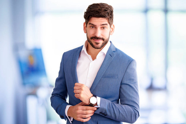 Portrait of handsome young financial assistant businessman standing in the office while looking at camera. - Photo, image