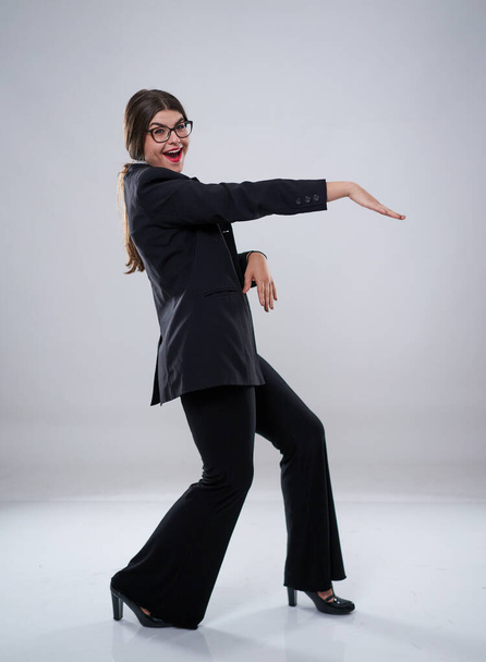 Vrolijke zakenvrouw dansend van vreugde in formeel pak - Foto, afbeelding