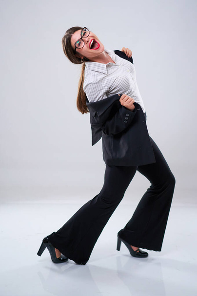 Cheerful businesswoman dancing with joy in formal suit - Foto, afbeelding