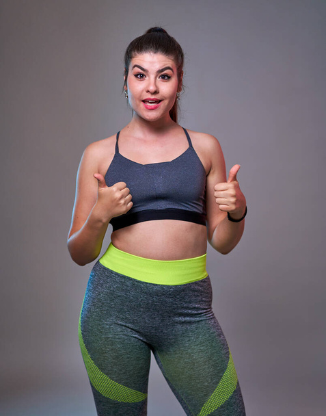 Plus size confident beautiful young woman doing fitness exercises, blue-red toning, studio shot - Zdjęcie, obraz