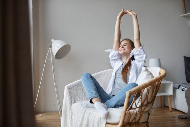 Joyful woman resting on comfortably chair at home. Domestic life. - Фото, изображение