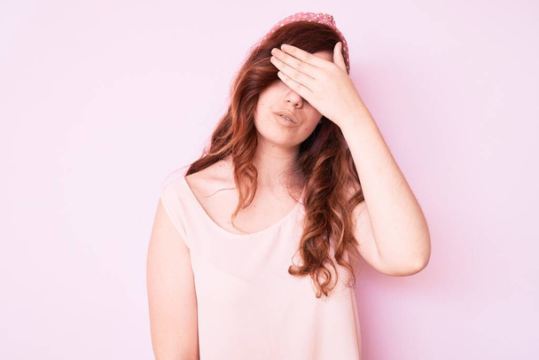 Young beautiful woman wearing casual clothes covering eyes with hand, looking serious and sad. sightless, hiding and rejection concept  - Foto, Imagem