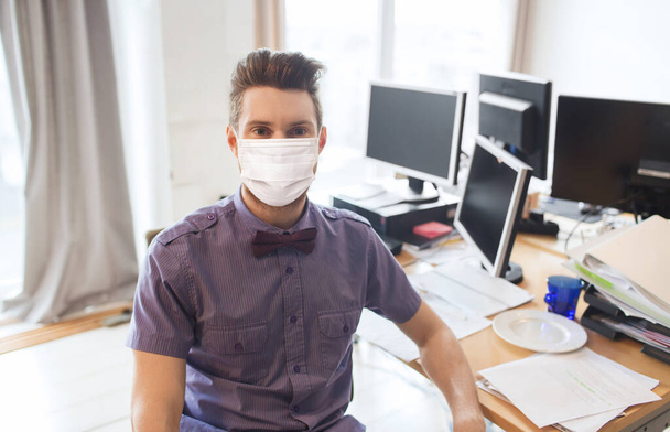 male office worker in mask with computers - 写真・画像
