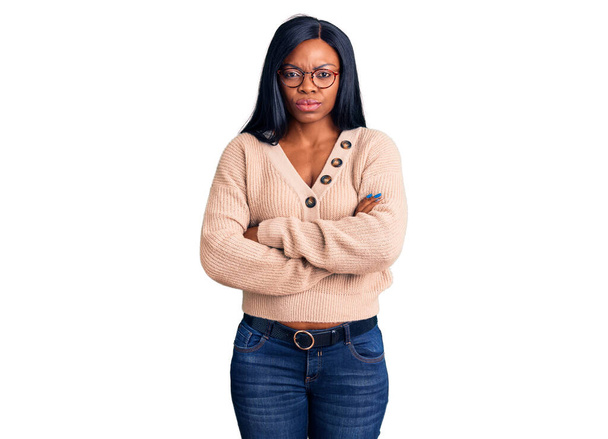 Jonge Afro-Amerikaanse vrouw draagt nonchalante kleren sceptisch en nerveus, afkeurende uitdrukking op gezicht met gekruiste armen. negatieve persoon.  - Foto, afbeelding