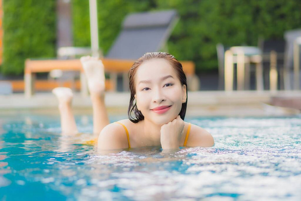 Portrét krásná mladá asijská žena relax úsměv volný čas kolem venkovního bazénu v prázdninovém výlety - Fotografie, Obrázek