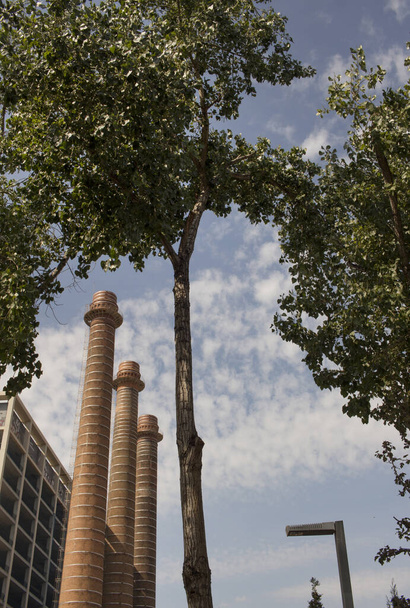 Три трубы старой фабрики на параллельном проспекте в районе Побле Сек в Барселоне, Каталония, Испания. - Фото, изображение