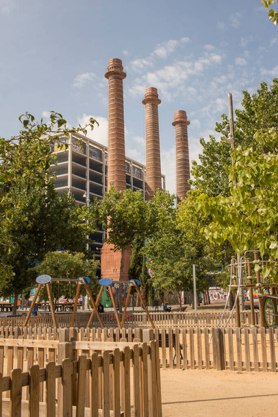 Trzy kominy starej fabryki na równoległej alei w dzielnicy Poble Sec w Barcelonie, Katalonia, Hiszpania. - Zdjęcie, obraz