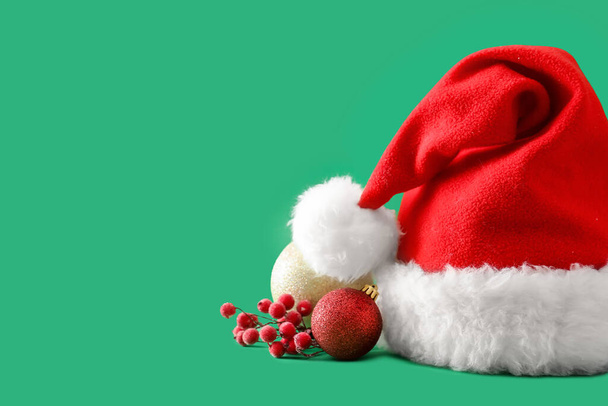 Santa hat and Christmas decor on color background - Photo, Image