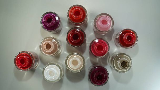 Open multi-colored nail polishes. Top view. Open bottles of nail polish. Women's cosmetics. - Photo, Image