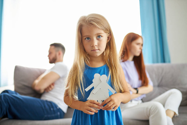 caucasian child girl holding family picture drawing feeling upset about parents divorce - Fotó, kép