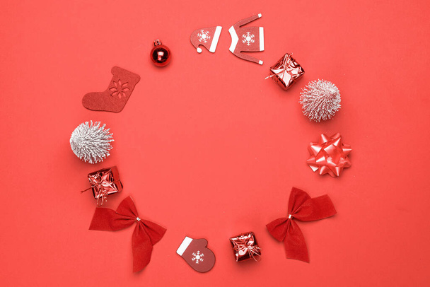 Vánoční věnec. Punčochy, dárky, zimní strom, stuha a luk ve tvaru rámu na červeném pozadí pro pozdrav karty. Vánoční pozadí s prostorem pro text - Fotografie, Obrázek