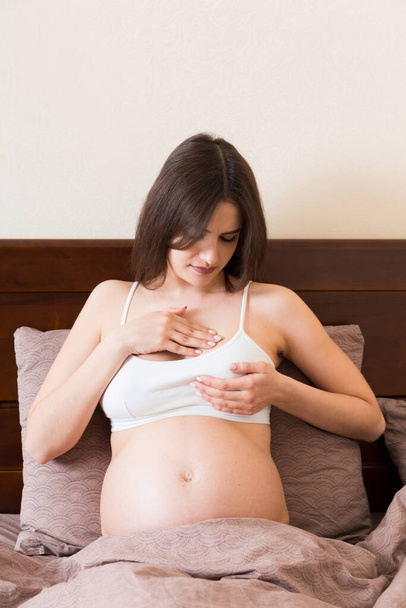Close Up kobiet w ciąży mających bolesne uczucia w piersi. Kobieta sprawdzająca piersi pod kątem raka. - Zdjęcie, obraz