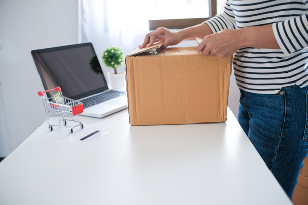 mujer que prepara la caja de entrega del paquete en el hogar compras en línea - Foto, Imagen