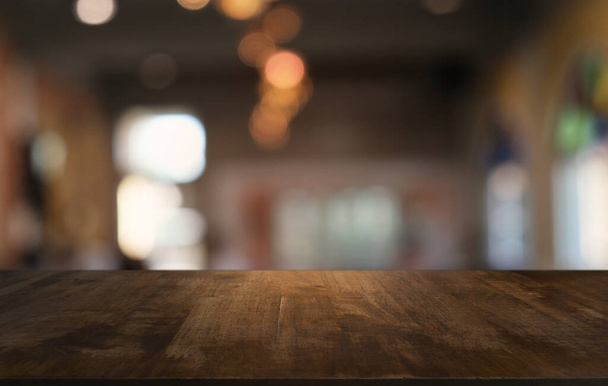 Tyhjä tumma puinen pöytä edessä abstrakti hämärtynyt bokeh taustalla ravintolassa. voidaan käyttää näyttämään tai montaasi tuotteita.Mallintaa tilaa  - Valokuva, kuva