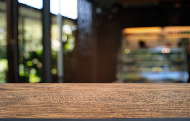Mesa vacía de madera oscura frente al abstracto fondo borroso bokeh del restaurante. se puede utilizar para la exhibición o el montaje de sus products.Mock para arriba para el espacio  - Foto, Imagen