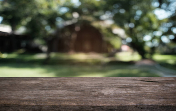 Leerer dunkler Holztisch vor abstrakt verschwommenem Bokeh-Hintergrund eines Restaurants. kann zur Anzeige oder Montage Ihrer Produkte verwendet werden. Mock up for space  - Foto, Bild