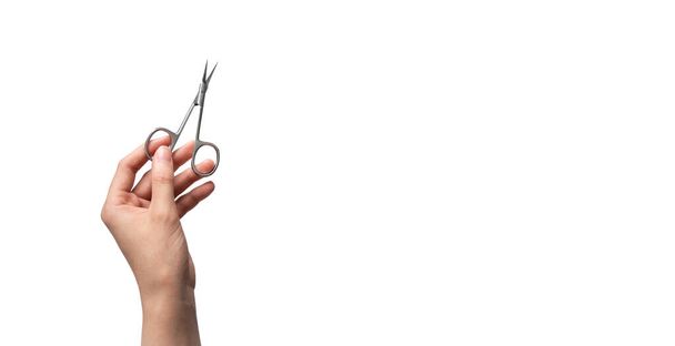 Weibliche Hand hält zweckmäßige Schere isoliert auf weißem Hintergrund mit Kopierraum, waagerecht. Maniküre und Pediküre Nagelpflege Tool - Foto, Bild